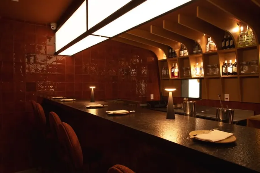 Composição visual do balcão do Kobi Izakaya com identidade japonesa e luz quente